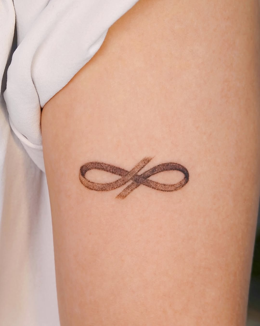 Delicate infinity symbol with floral accents Tattoo Design