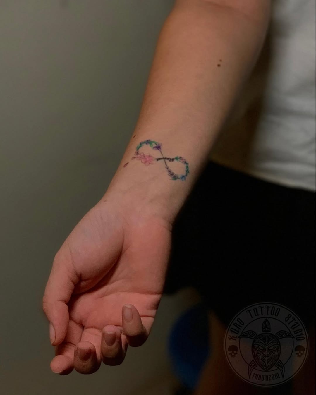 Elegant infinity tattoo with a feather design Tattoo Design