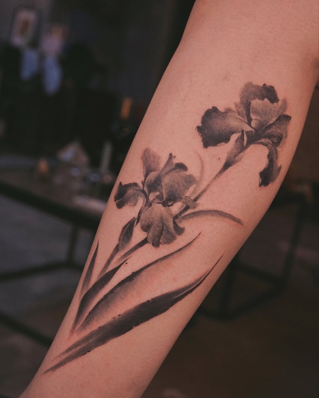 This stunning iris tattoo showcases intricate details in black and gray ink.