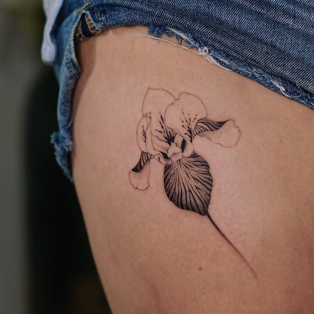 This iris tattoo showcases a delicate bloom with detailed shading.