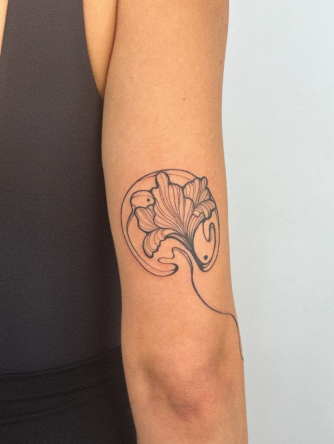 This tattoo showcases a minimalist design of an iris flower, beautifully wrapping around the arm.