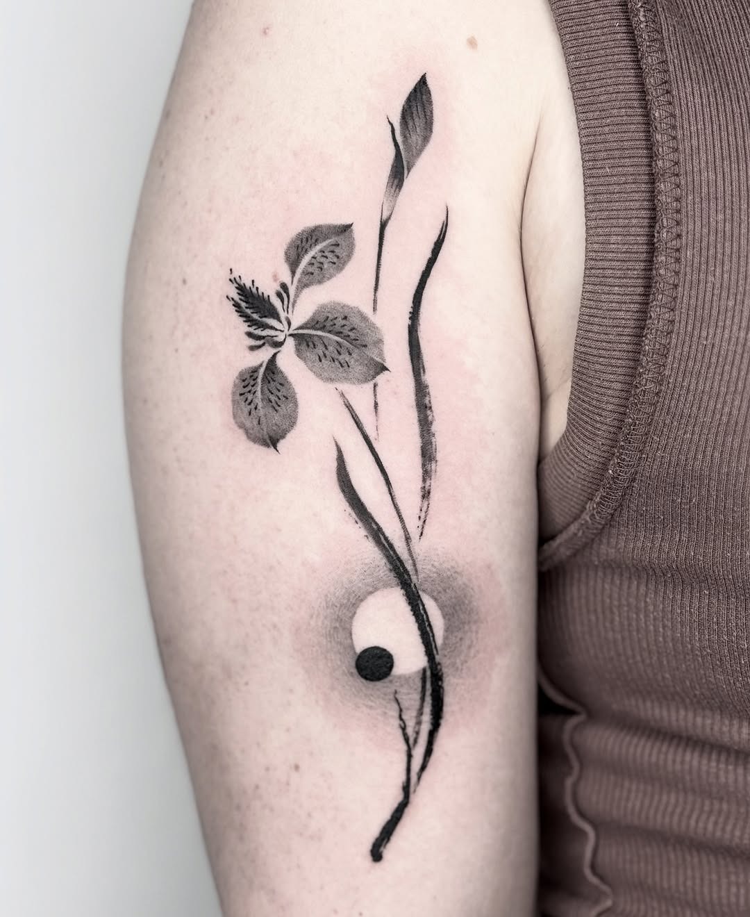 This stunning iris tattoo blends intricate floral designs with clean lines.