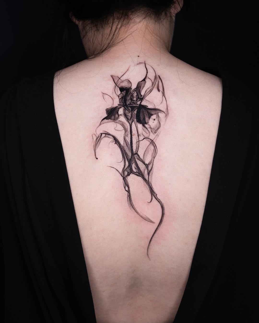 This stunning iris tattoo features delicate lines and subtle shading, creating a fluid, artistic design.