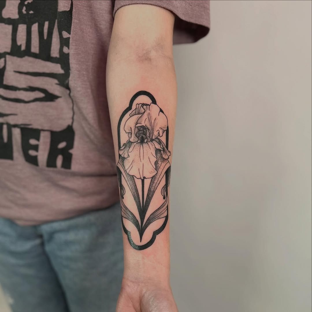This iris tattoo features intricate blackwork with bold outlines, showing the delicate beauty of the flower.