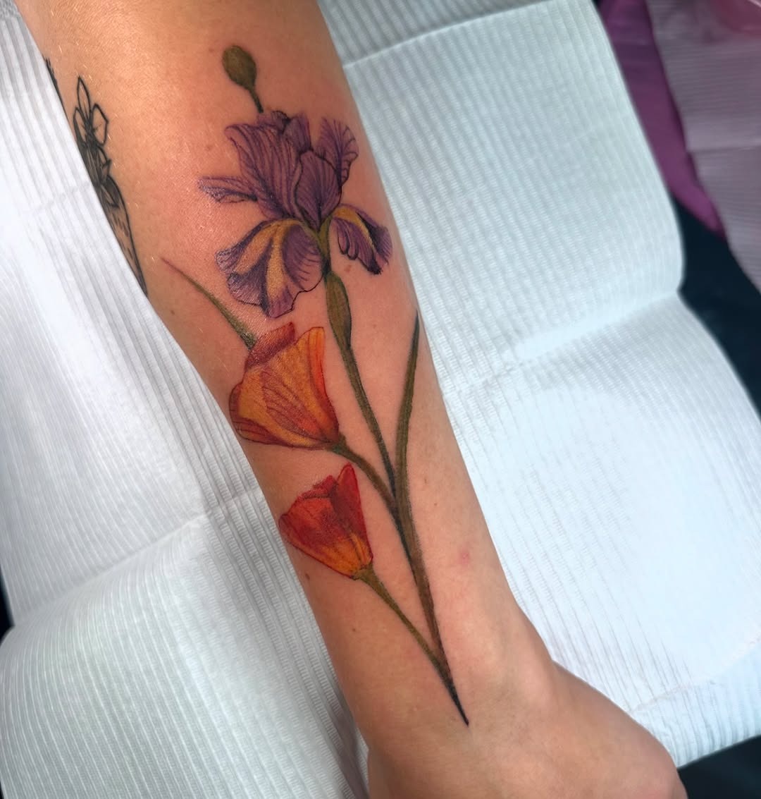 This tattoo showcases delicate irises and blooms.