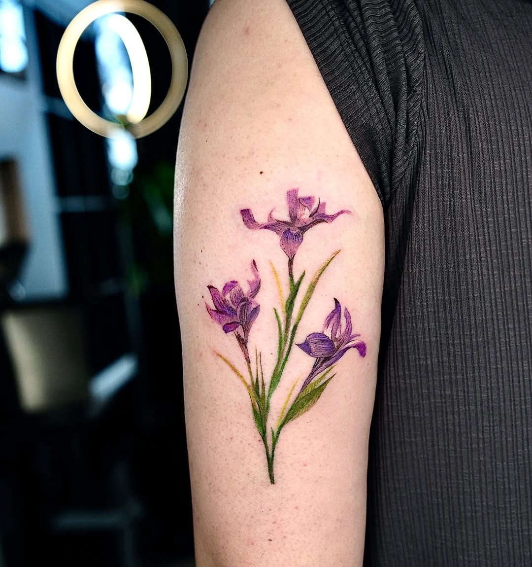 This iris tattoo incorporates stunning shades of purple, bringing life to the wearer's arm.