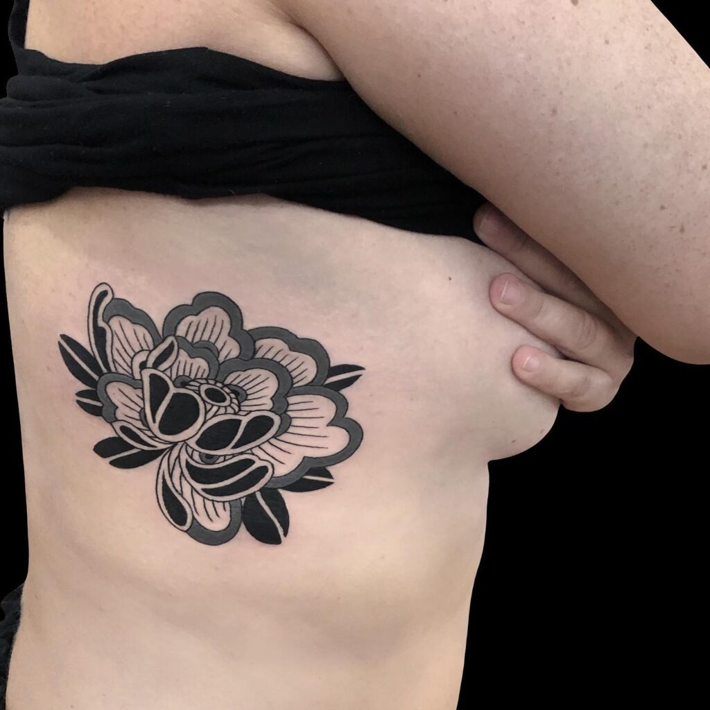 Bold Peony Rib Tattoo in Blackwork Tattoo Design