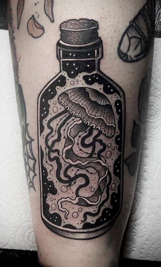 Neo traditional glass bottle tattoo holding a glowing miniature jellyfish and cosmic stardust