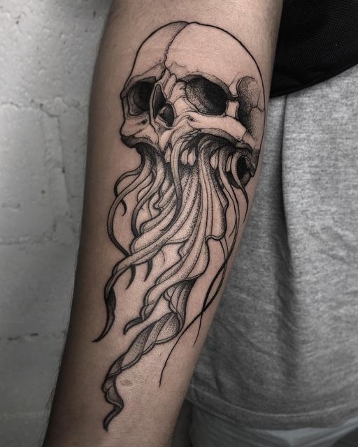 Dark blackwork memento mori tattoo blending an anatomical human skull with a drifting jellyfish