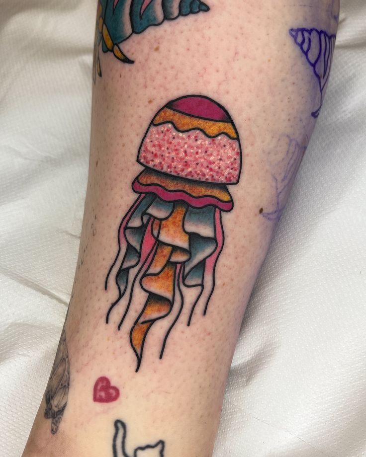 Bold neo traditional jellyfish tattoo with electric magenta, teal, and gold color saturation