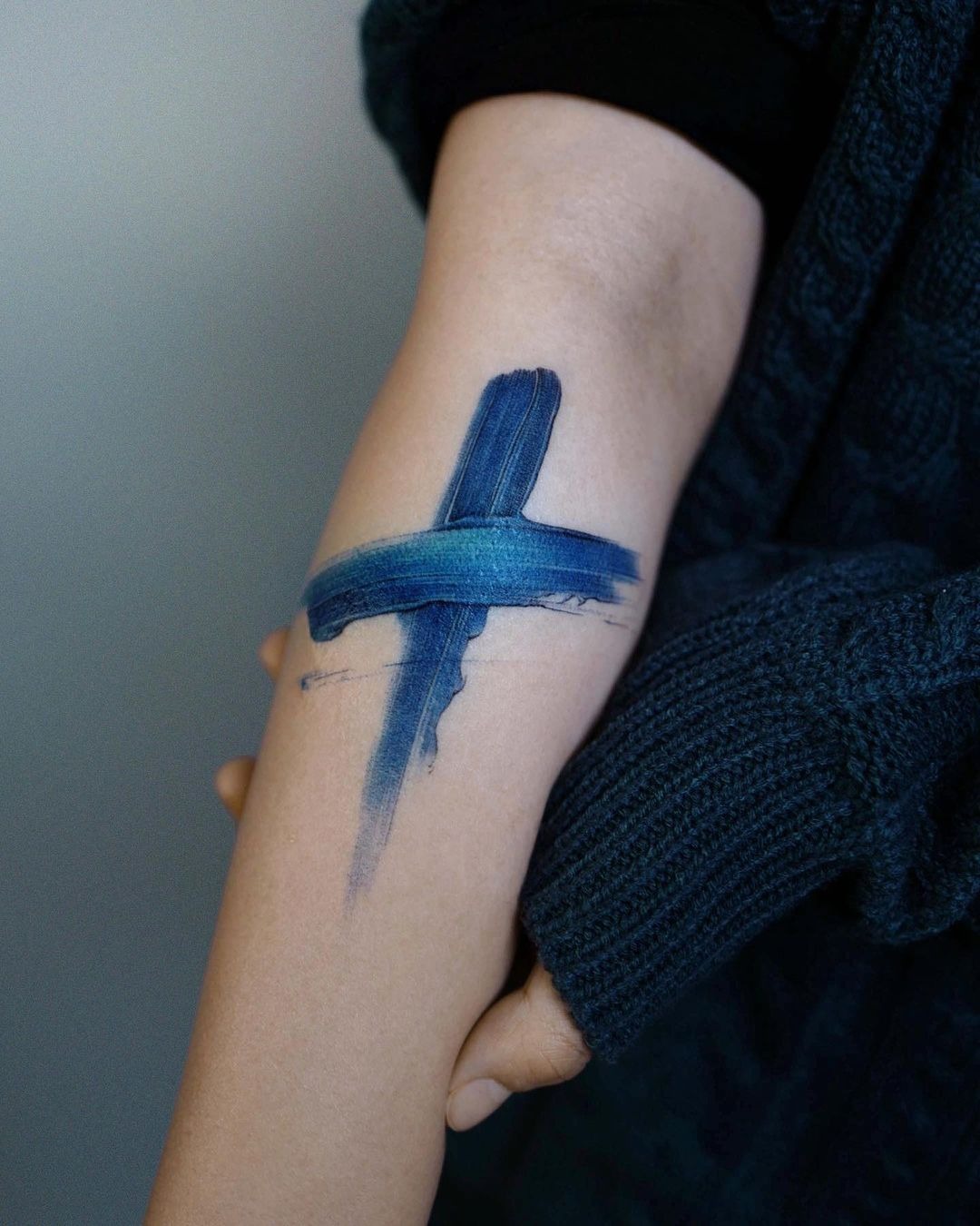 Blue Painted Cross Tattoo with a Faded Base Tattoo Design