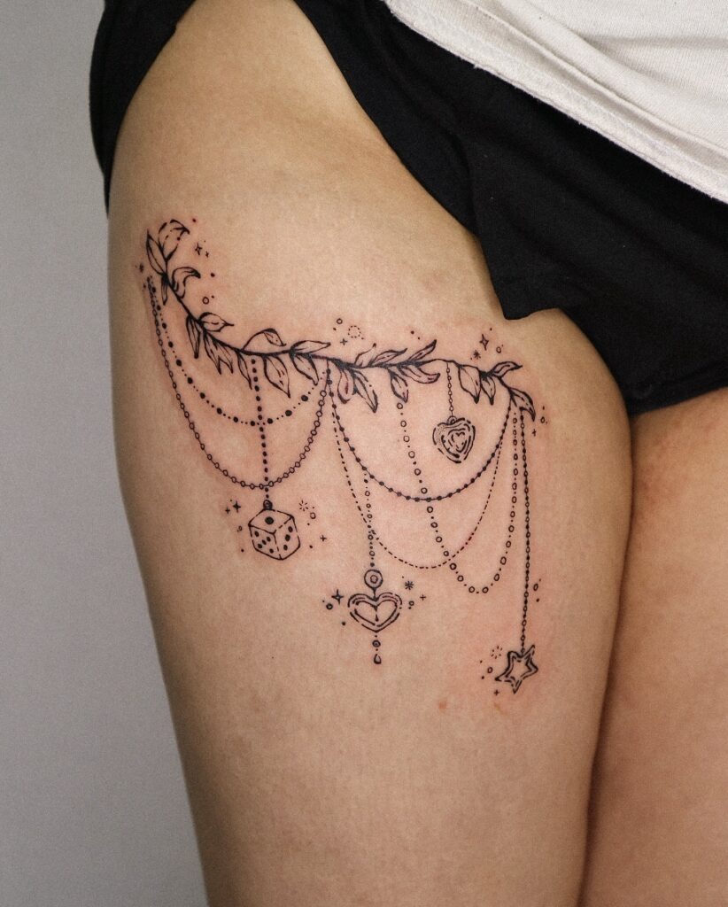 Whimsical Charm Chain Thigh Tattoo Tattoo Design