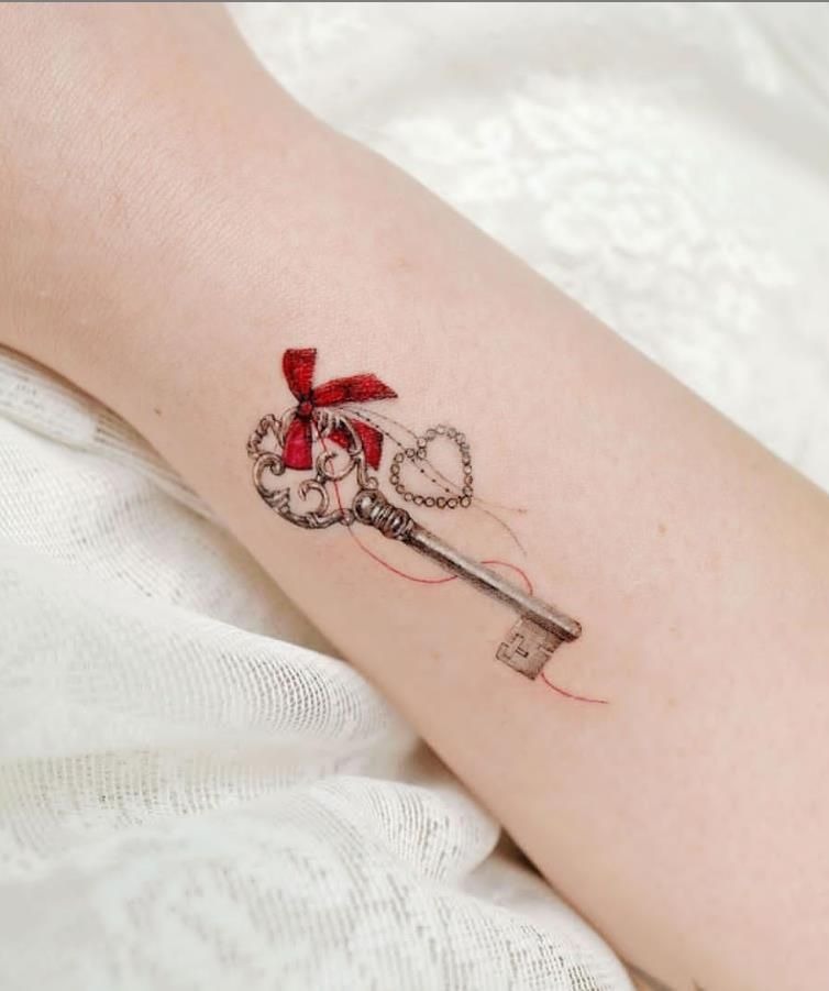 Delicate Key with Red Ribbon Accent Tattoo Design