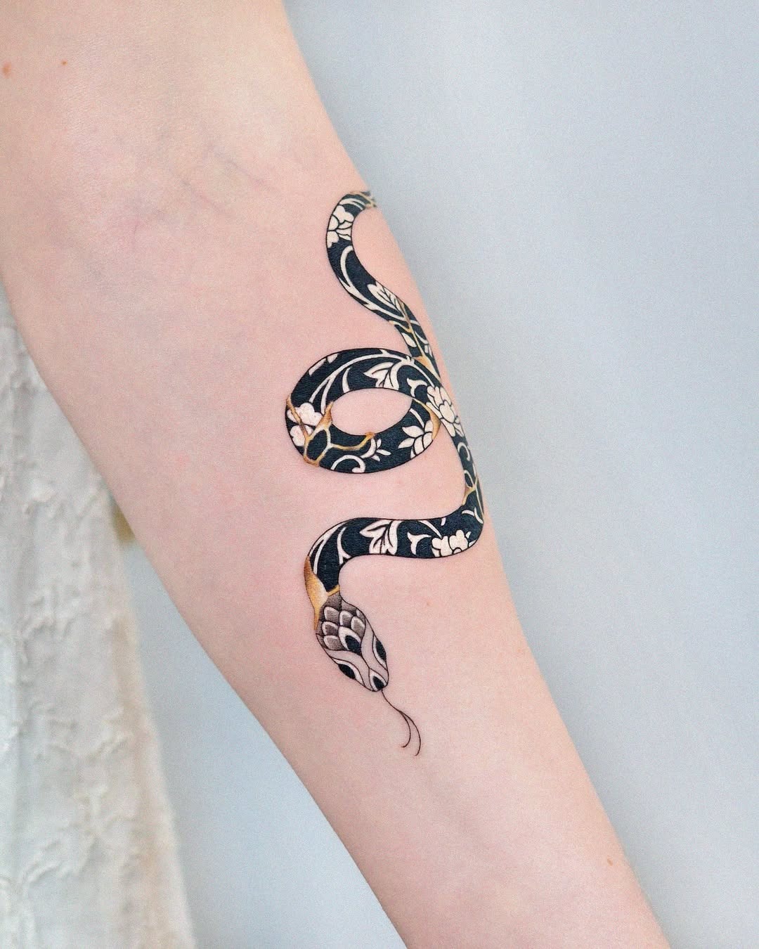 Intricate snake tattoo with floral kintsugi design Tattoo Design