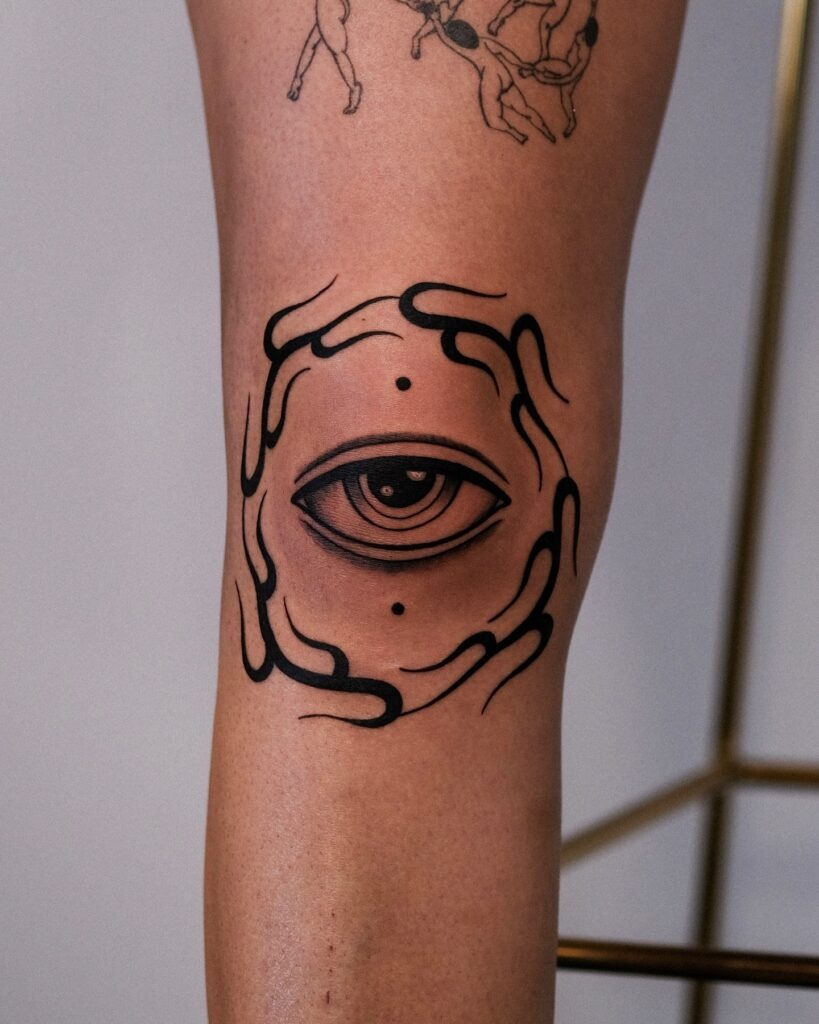 All-Seeing Eye with Flame-Inspired Knee Frame Tattoo Design