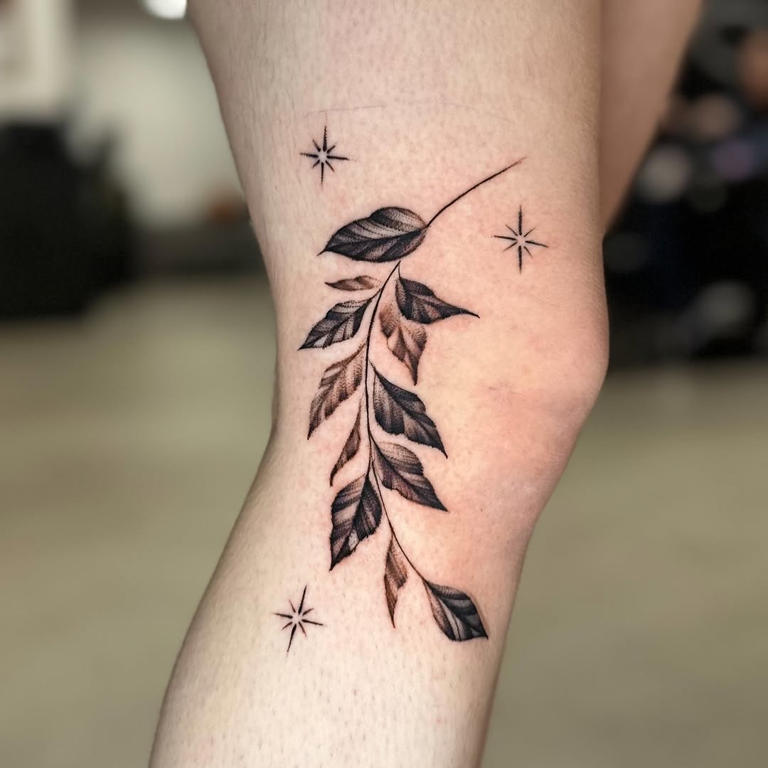 Elegant knee tattoo design featuring leaves and stars. Tattoo Design