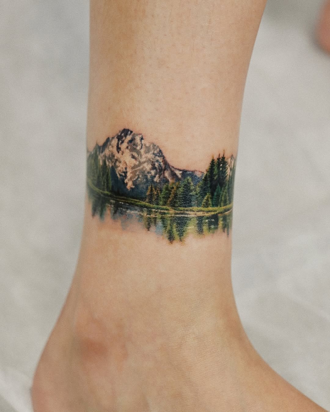 Stunning ankle tattoo with mountain reflection Tattoo Design