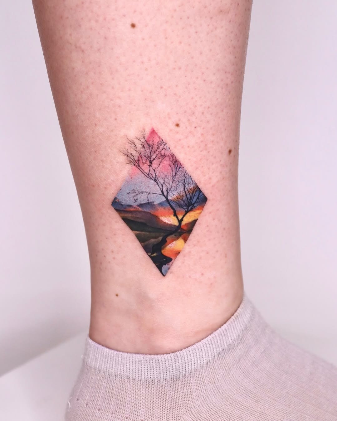 Stunning diamond-shaped sunset landscape tattoo Tattoo Design