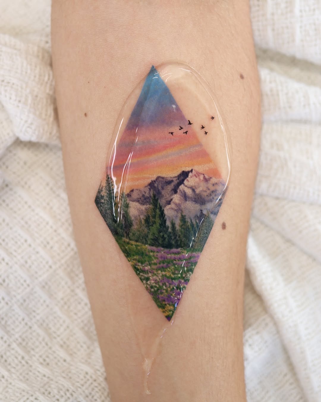 Vibrant landscape tattoo with geometric framing Tattoo Design