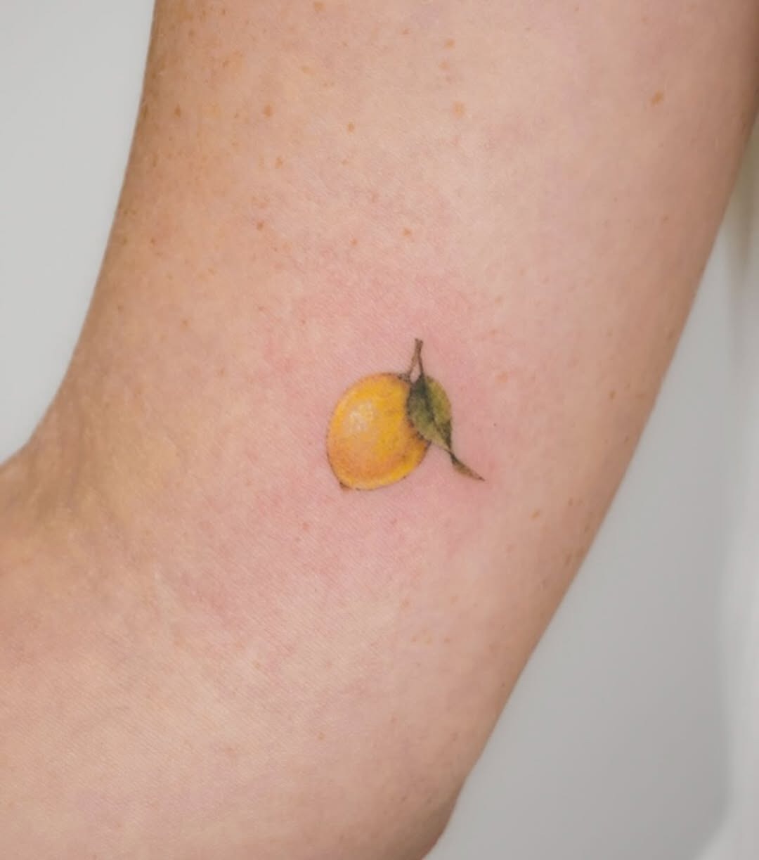 Charming lemon tattoo on a delicate arm Tattoo Design