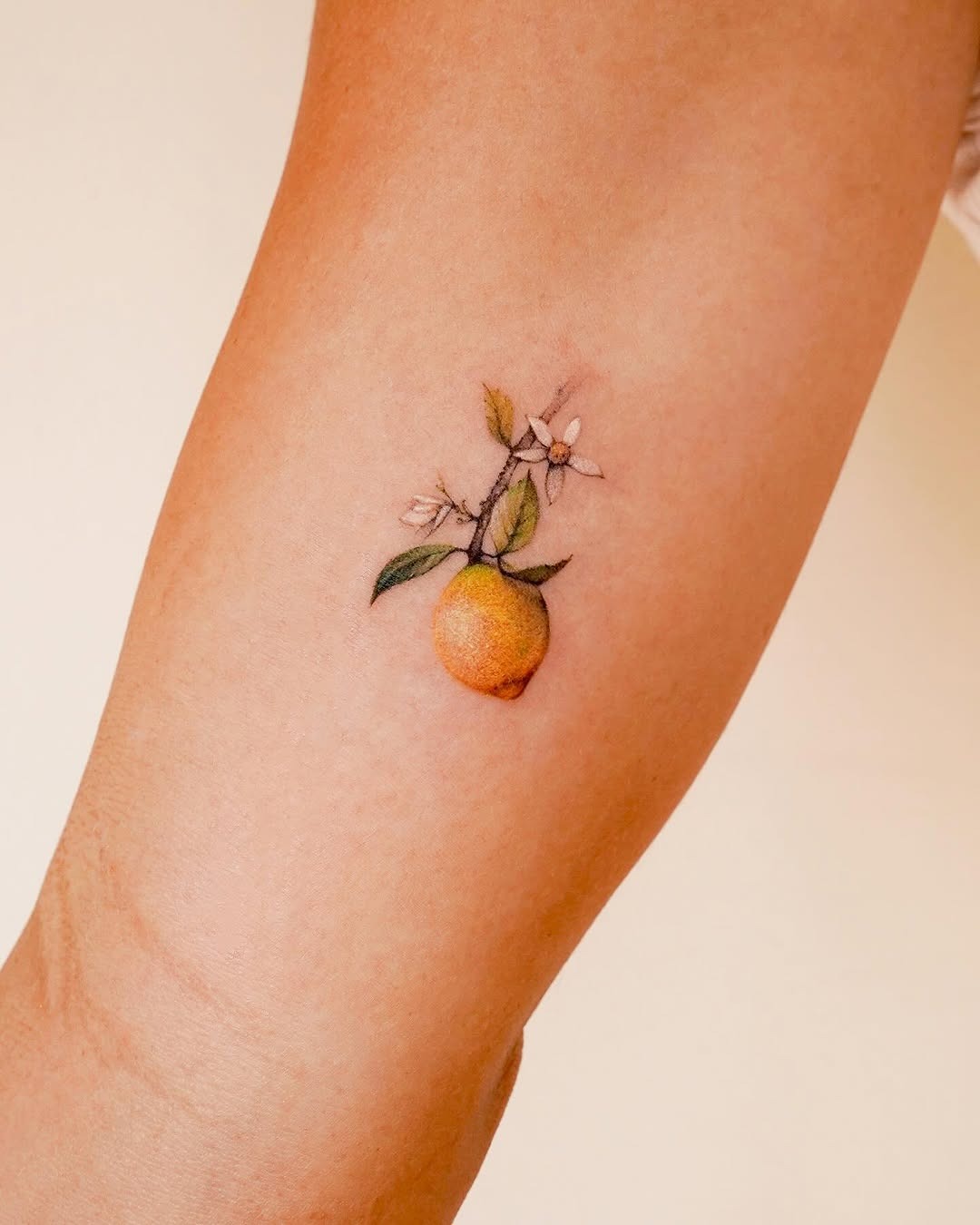 Charming lemon tattoo with floral accents Tattoo Design