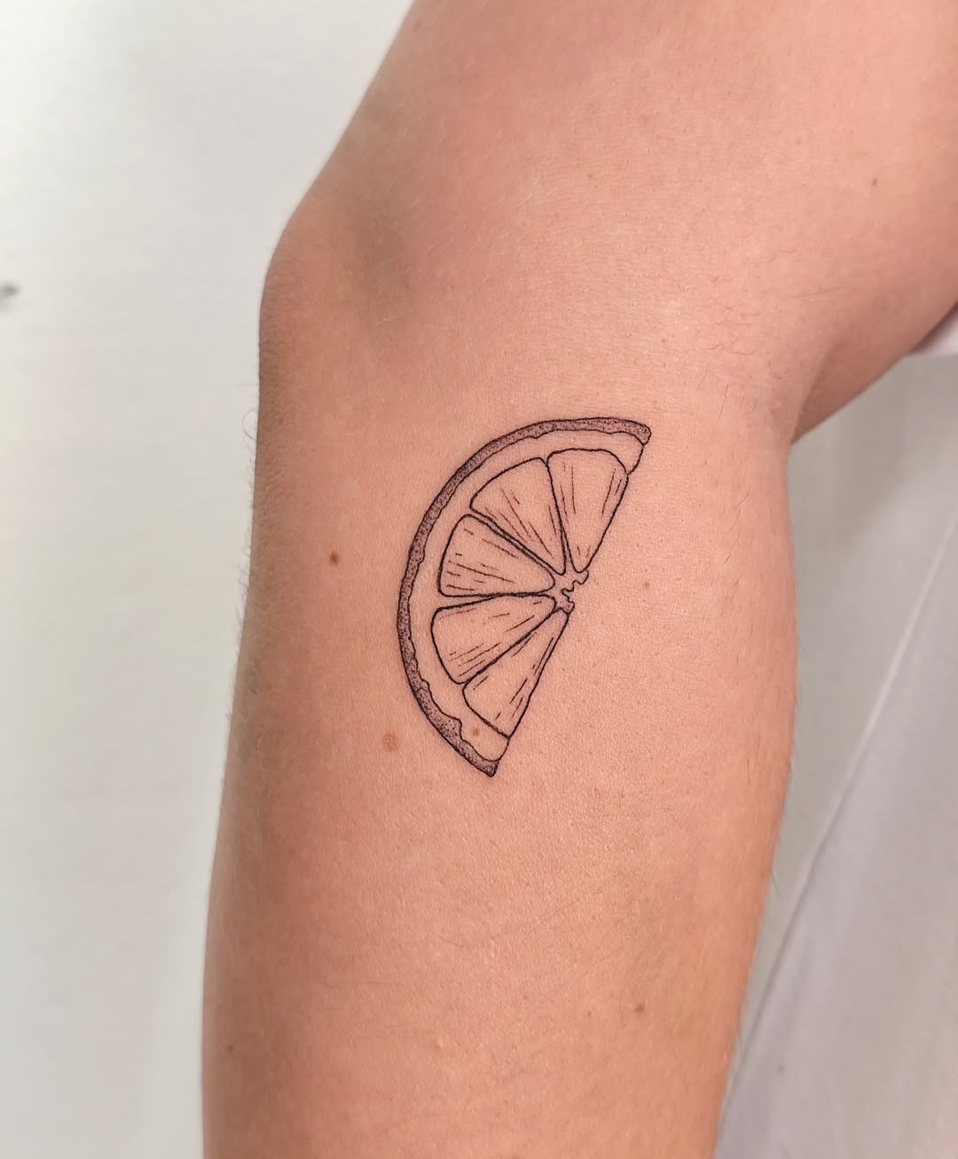 Minimalist lemon slice tattoo on the arm Tattoo Design