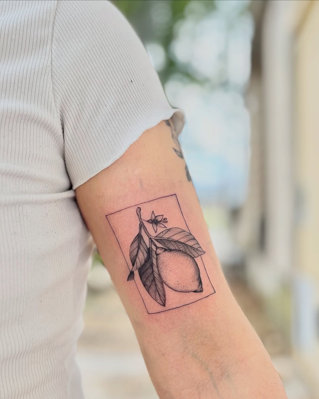 Minimalist lemon tattoo with delicate floral accents Tattoo Design