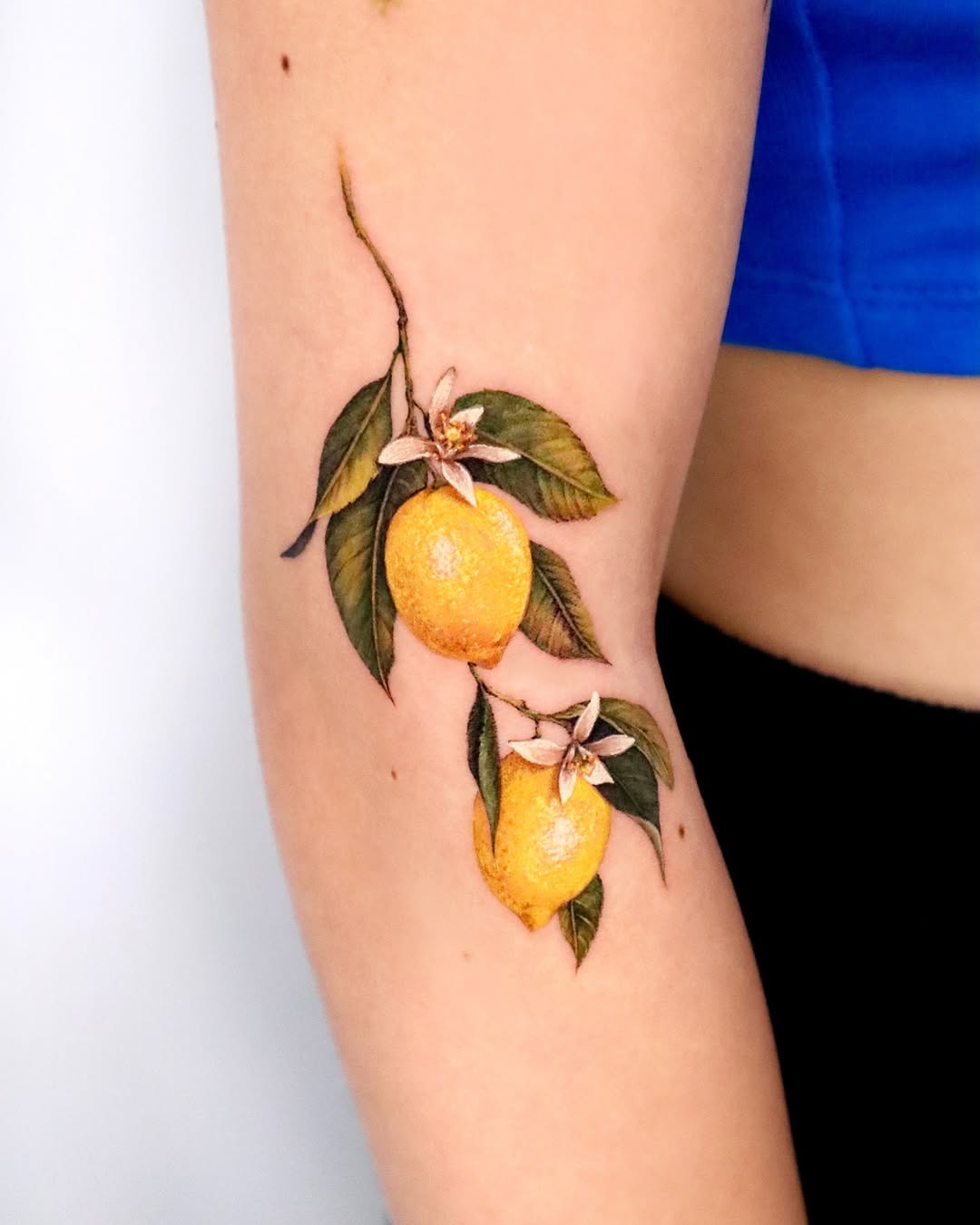 Vibrant lemon tattoo with floral accents Tattoo Design