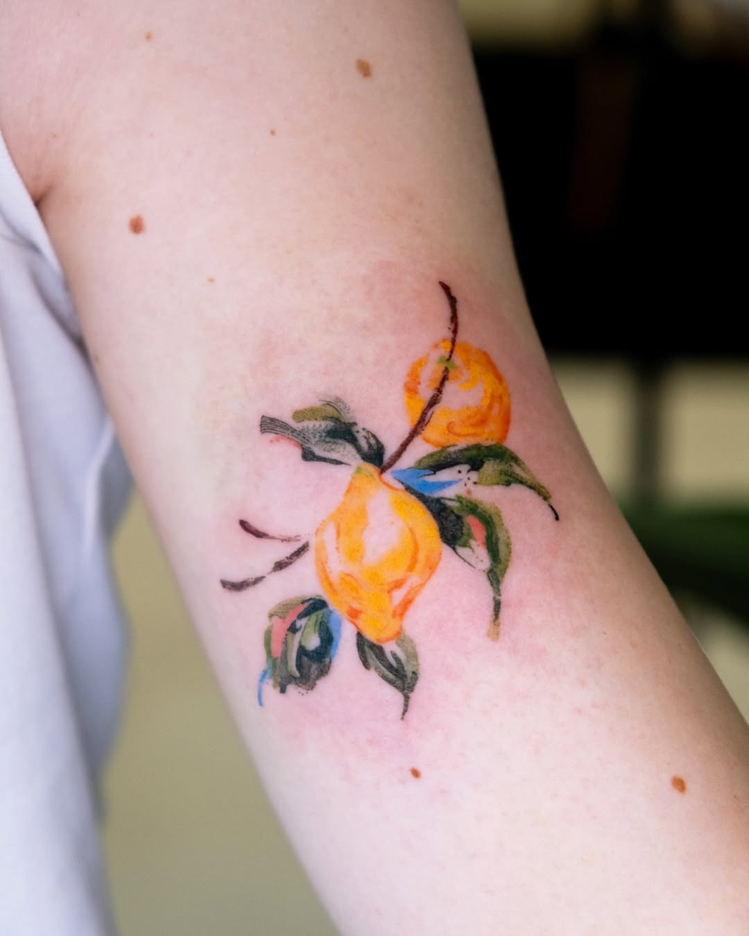 Vibrant lemon tattoo with floral accents Tattoo Design