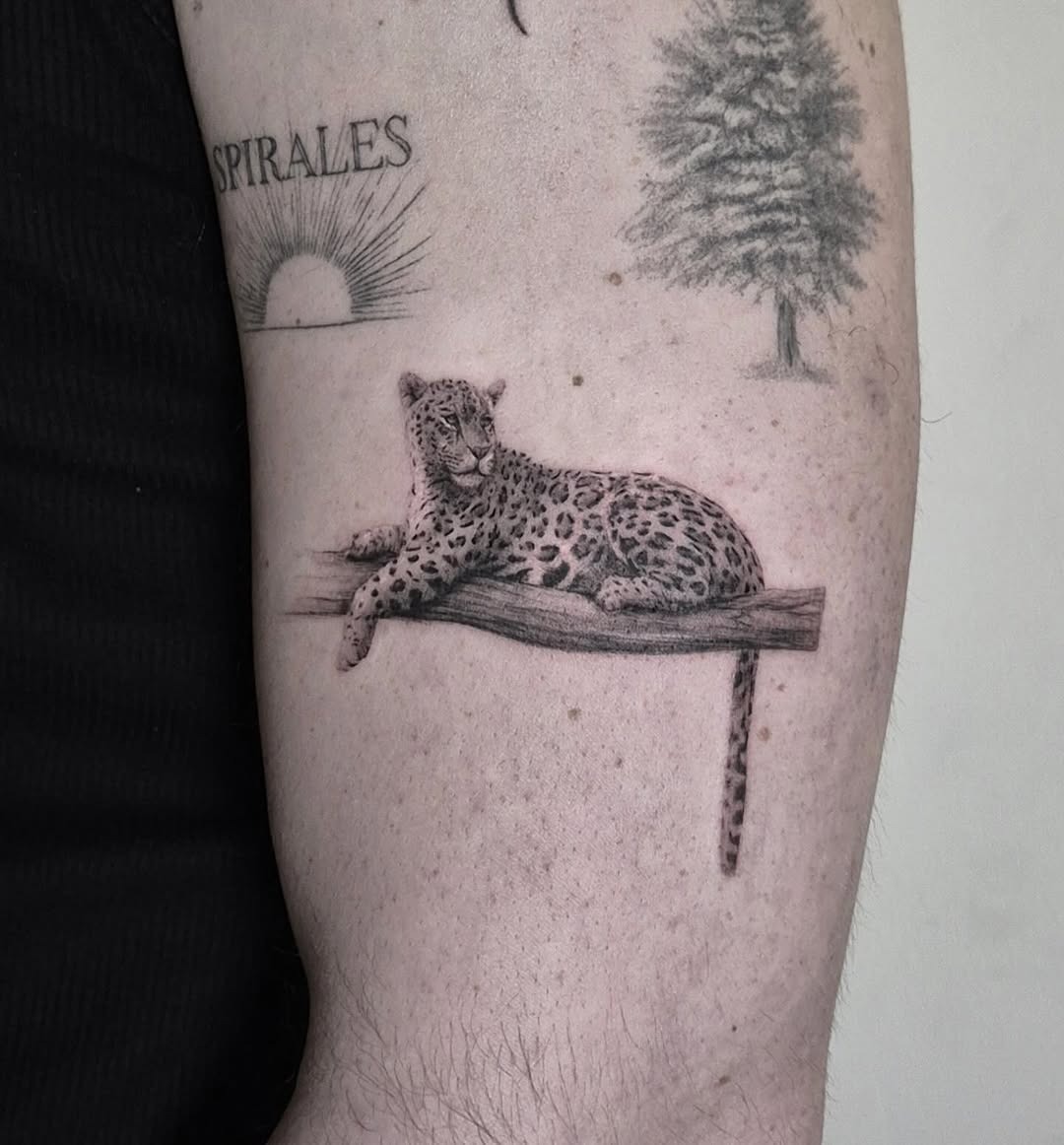 Charming leopard tattoo resting on a branch Tattoo Design