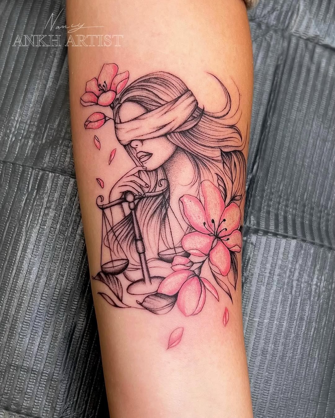 This tattoo showcases a blindfolded woman holding scales, symbolizing justice and balance, the core traits of Libra.
