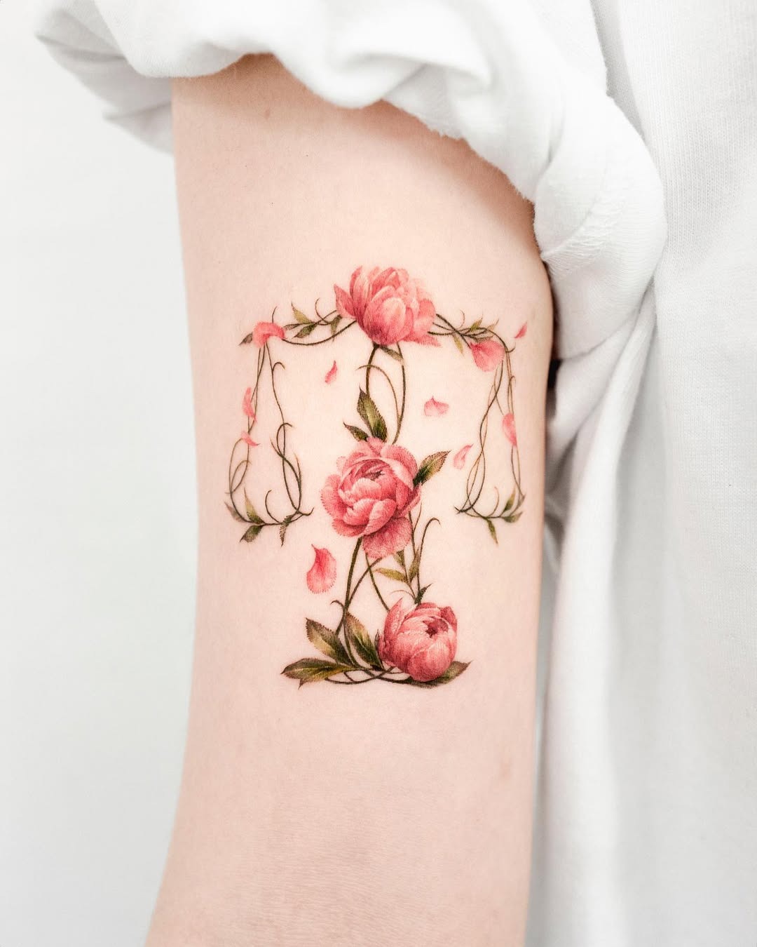 This stunning Libra tattoo combines delicate roses with a scales motif, representing harmony and balance.
