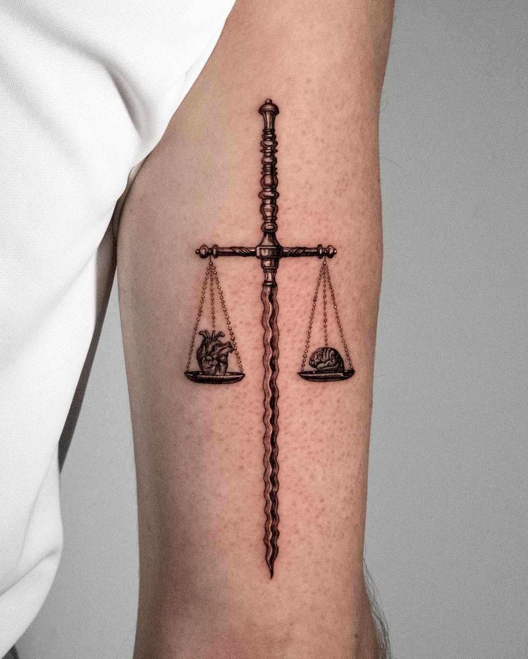 This stunning tattoo features the Libra scales elegantly balanced on a sword, symbolizing justice and harmony.