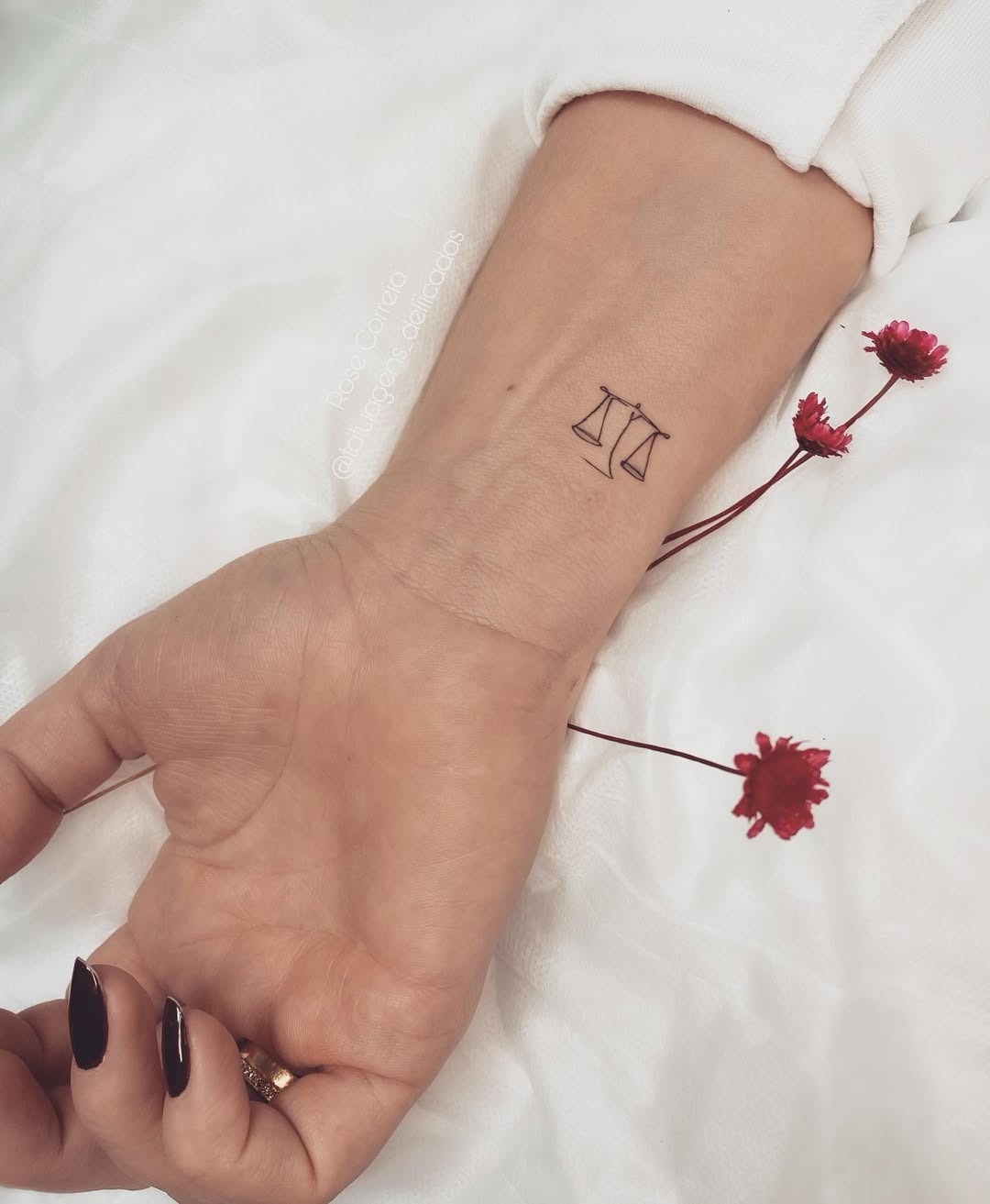 This delicate tattoo features the iconic Libra scales, symbolizing balance and harmony.