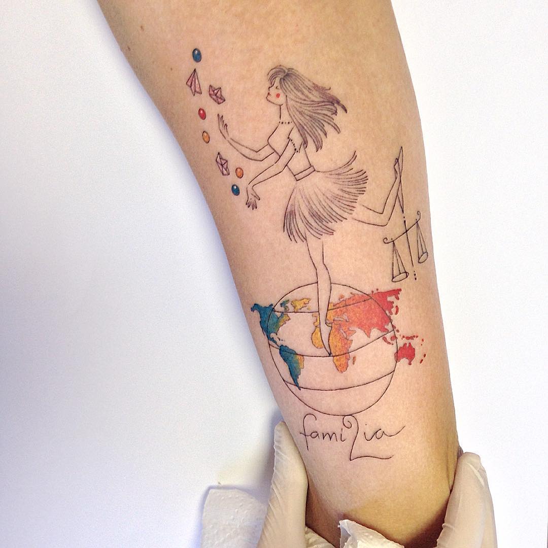 This Libra tattoo features a whimsical woman dancing atop a globe, balancing scales in her hand.