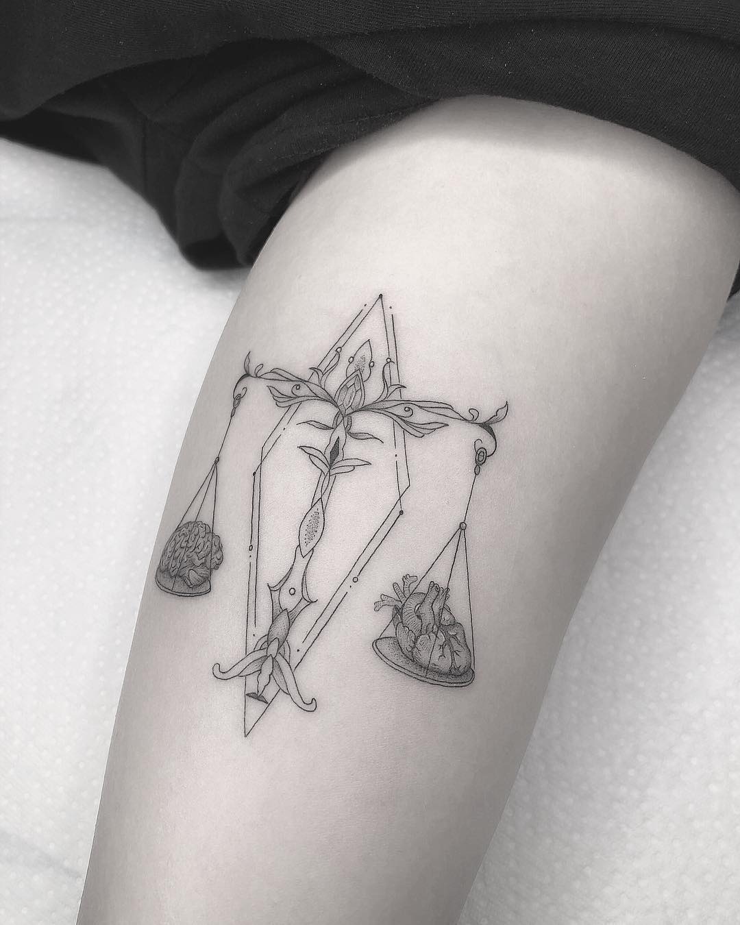 This Libra tattoo beautifully represents balance with scales featuring a heart and brain.