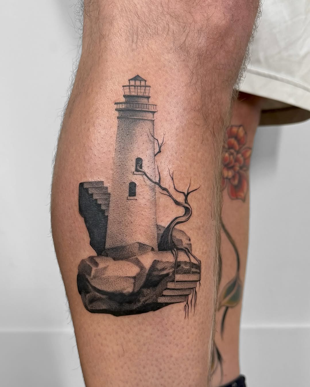Intricate lighthouse tattoo on leg, showcasing artistry Tattoo Design