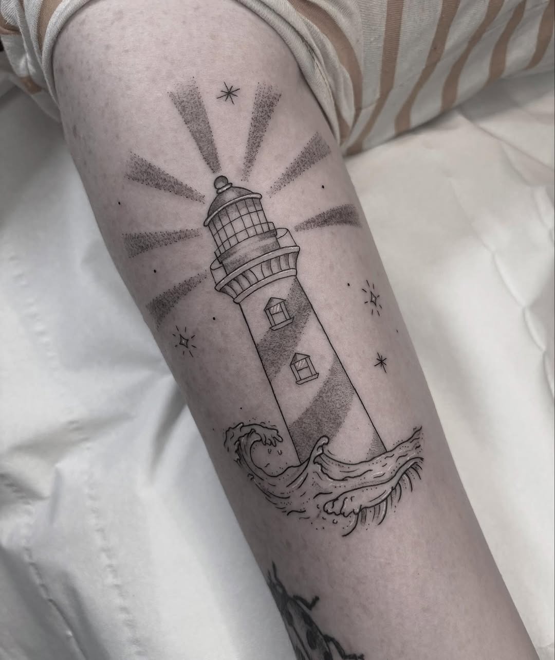 Intricate lighthouse tattoo with radiant waves Tattoo Design
