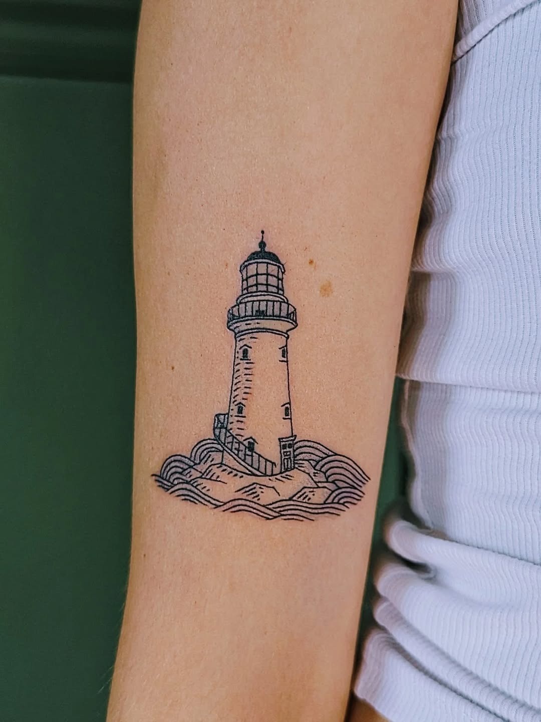 Minimalist lighthouse tattoo showcasing gentle waves Tattoo Design