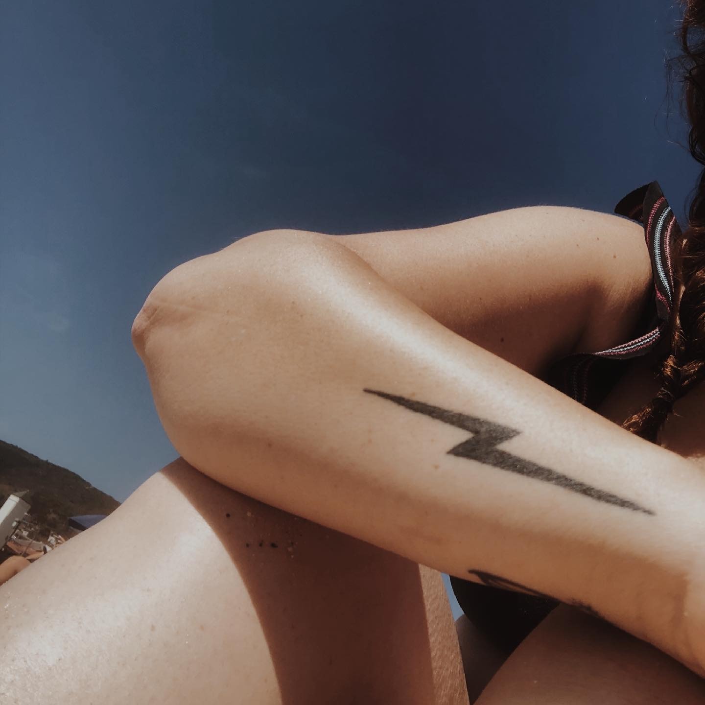 Sleek black lightning bolt tattoo on arm Tattoo Design