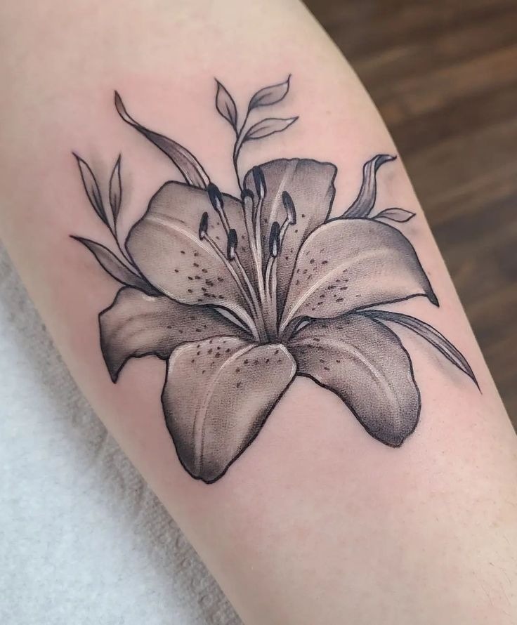 This simple lily tattoo focuses on a single bloom, bringing attention to the flower's intricate details.