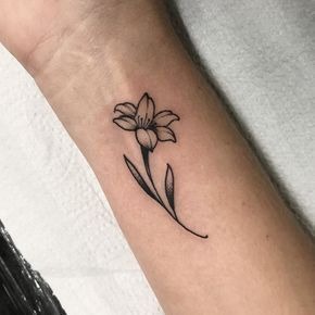 This small lily tattoo placed on the forearm uses minimal lines to create a beautiful yet subtle design.