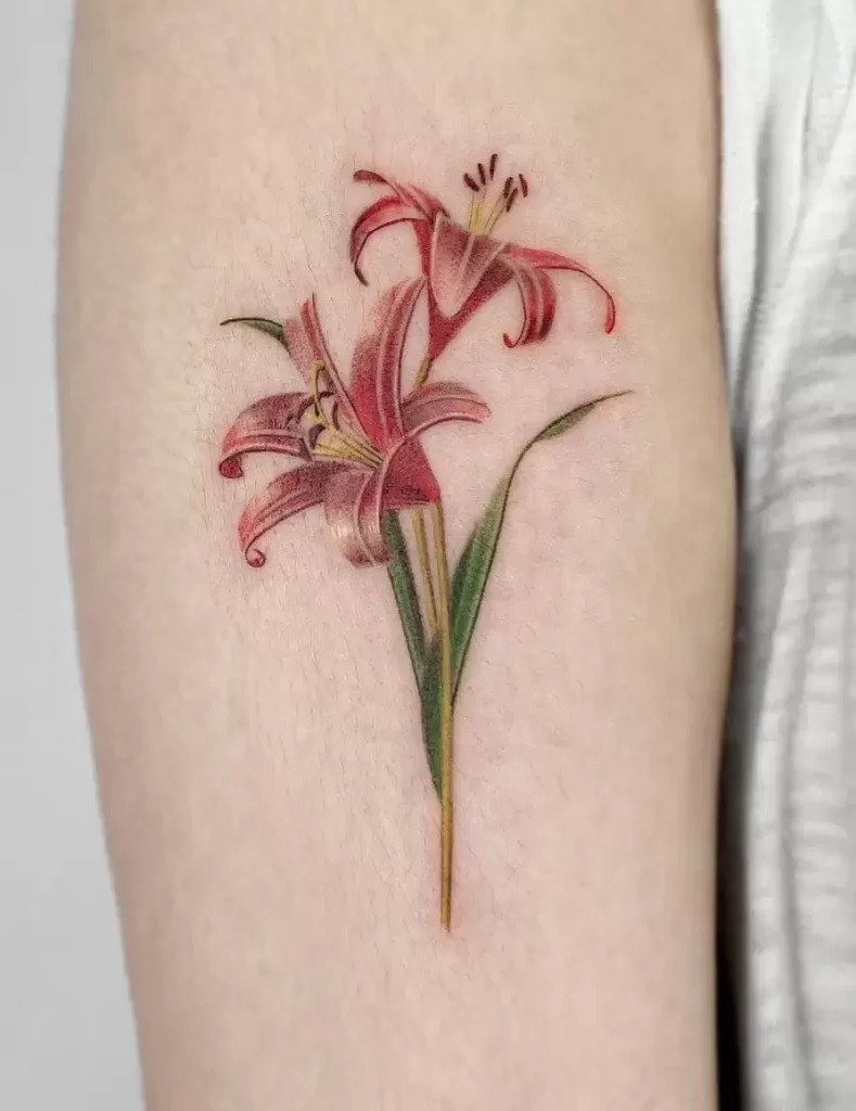 This arm tattoo features two lilies, delicately placed with minimal shading and soft colors.