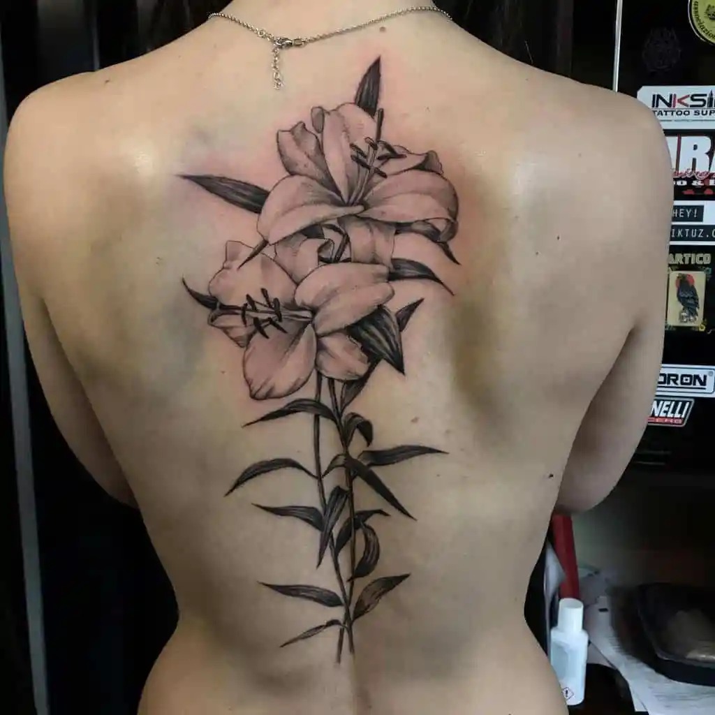 This back tattoo is a striking example of how the lily flower can be transformed into a spine tattoo.