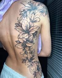 This stunning back tattoo features a cascade of lilies that run down the entire length of the spine.