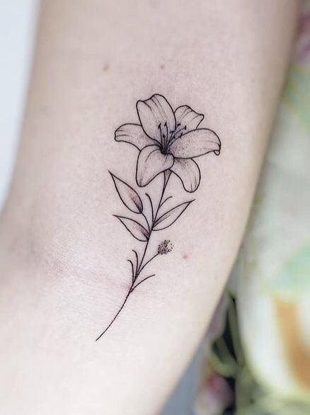 In this stunning realistic lily tattoo, the use of white and light shading brings the flower to life on the skin.