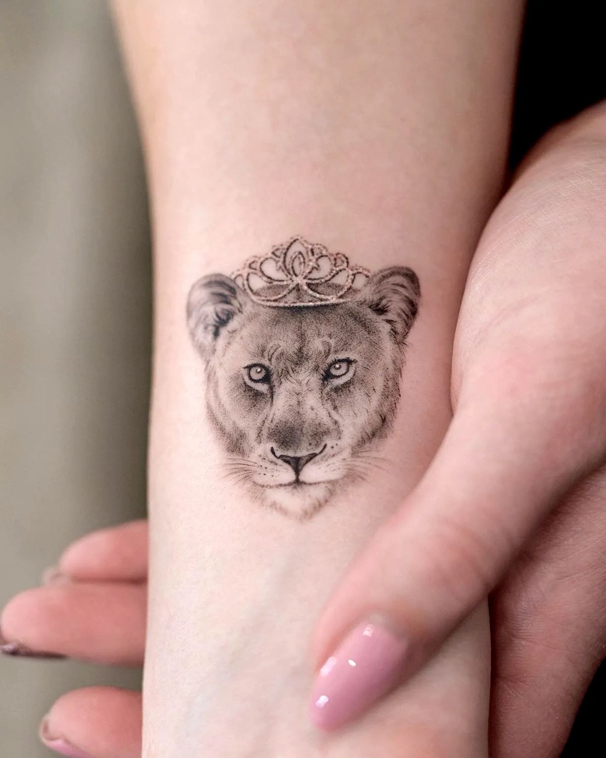 Petite Crowned Lioness Wrist Emblem Tattoo Design