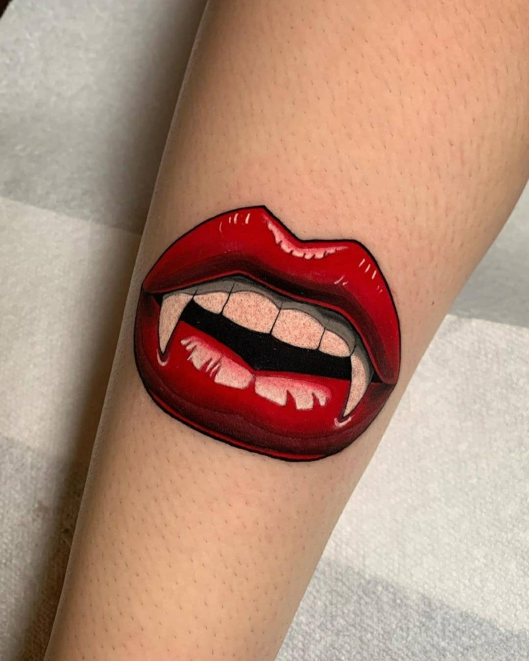 Bold lip tattoo with vampire fangs design Tattoo Design