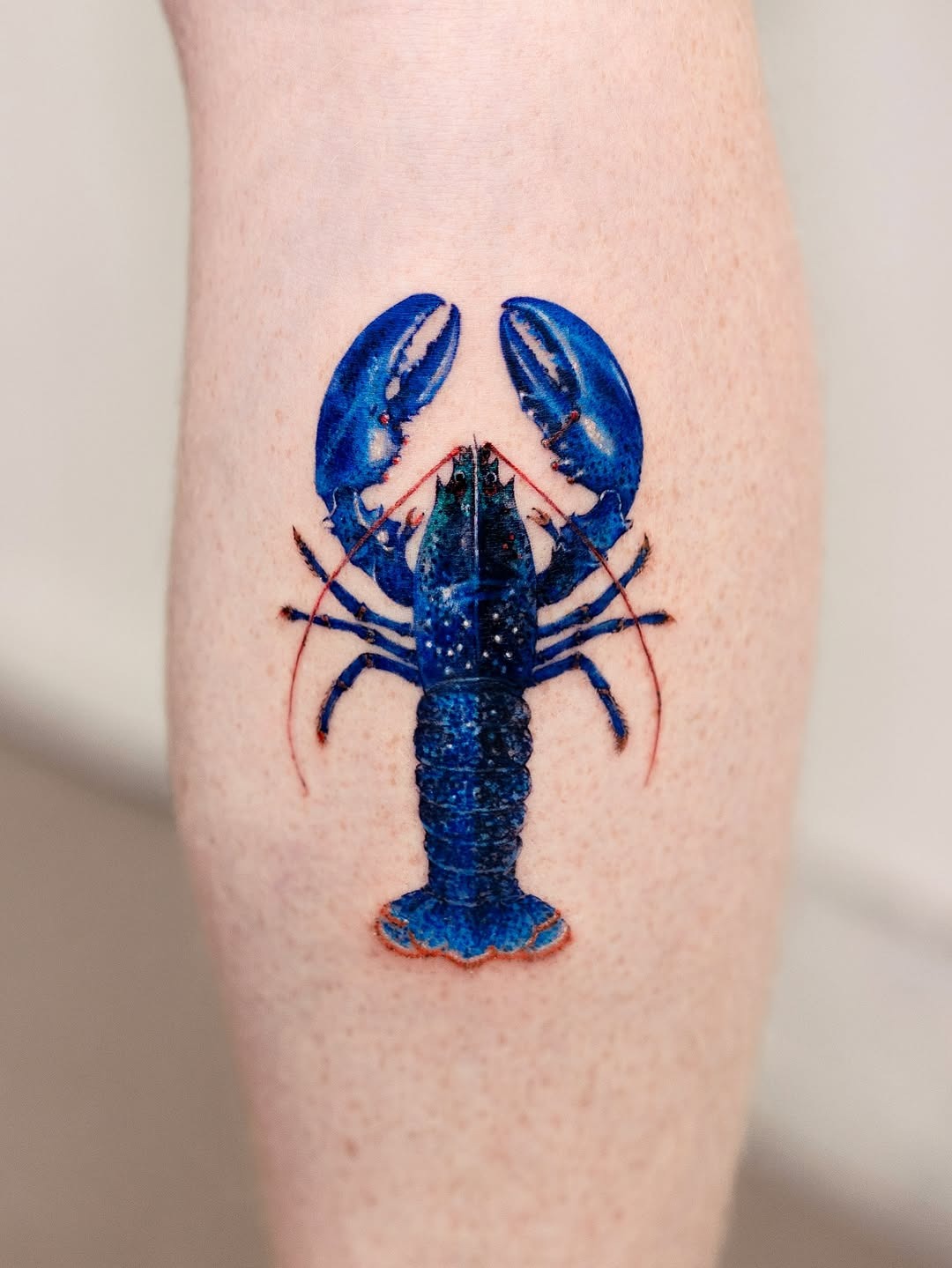 Vibrant blue lobster tattoo on forearm Tattoo Design