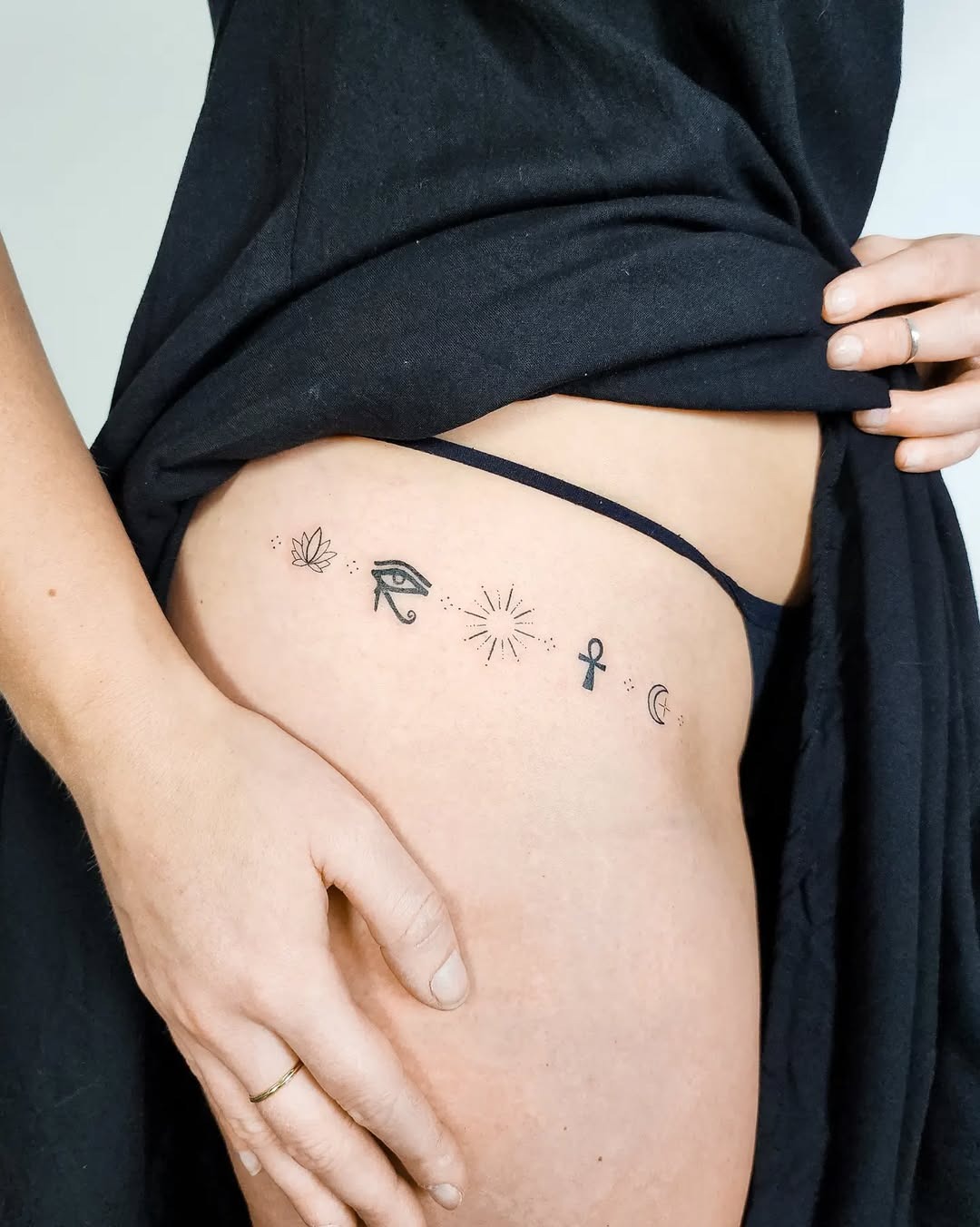 Minimalist lotus tattoo with spiritual symbols Tattoo Design